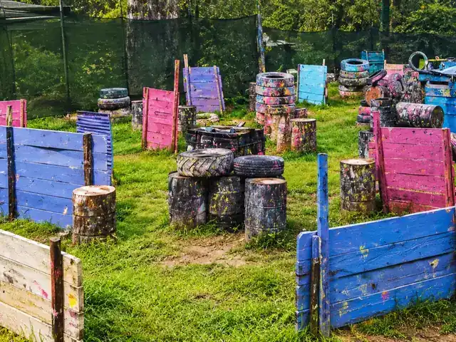Campo Urbano de Quito Woodsball: barricadas de madera de colores, llantas apiladas y barriles salpicados de pintura