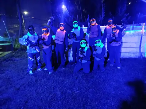Jugadores de Paintball Glow con máscaras y chalecos fluorescentes bajo luz ultravioleta en Quito Woodsball