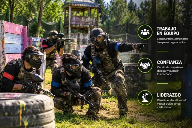 Equipo de paintball coordinando una jugada en el campo, con los pilares del team building: trabajo en equipo, confianza y liderazgo